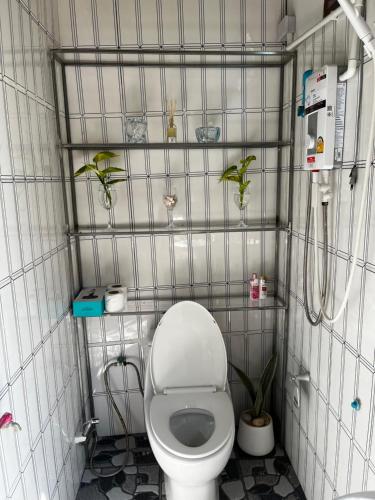 a small bathroom with a toilet and plants in it at Cozy breezing countryside Pet in Ban Khlong Sip Sam Lang