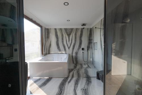 a bathroom with a tub and a large window at Villa Sefa Söğüt Daily Weekly Rentals in Kaygıseki