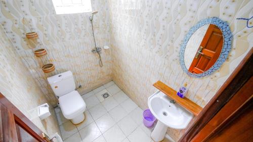 キガリにあるManna Stays, Kagaramaのトイレ、洗面台、鏡のあるバスルーム