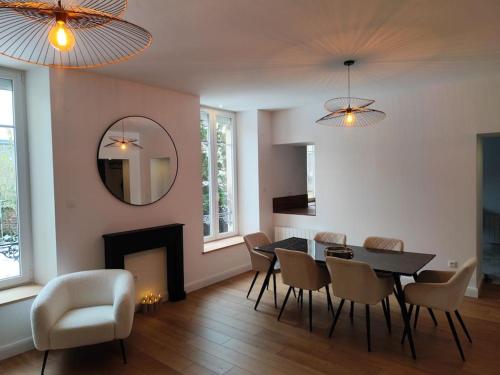 une salle à manger avec une table, des chaises et un miroir dans l'établissement Appartement chic proche centre, à Épinal