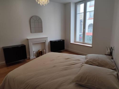 une chambre avec un grand lit et deux fenêtres dans l'établissement Appartement chic proche centre, à Épinal