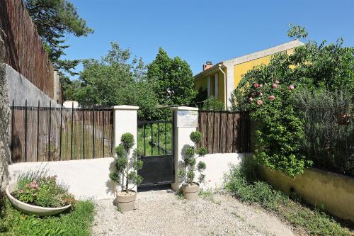 a fence with potted plants in front of a gate at Appartement Mas de Silvacane in La Roque-dʼAnthéron