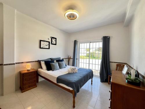 a bedroom with a bed and a large window at Pera Stylish Villa With Pool by Homing in Pêra