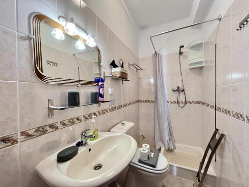 a bathroom with a sink and a toilet and a mirror at Pera Stylish Villa With Pool by Homing in Pêra