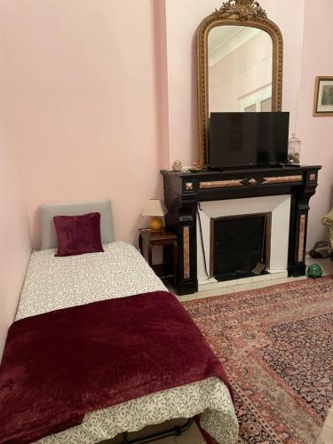 - une chambre avec un lit, un miroir et une télévision dans l'établissement L Étoile du Sud, à Sète