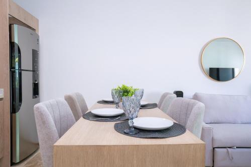 a dining room table with chairs and a mirror at Menesse Town Tower 202 condo in Playa del Carmen