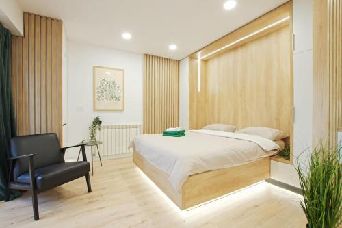 Un dormitorio con una cama y una silla dentro. en Designers Apartment - chic choice for the stay, en Iaşi
