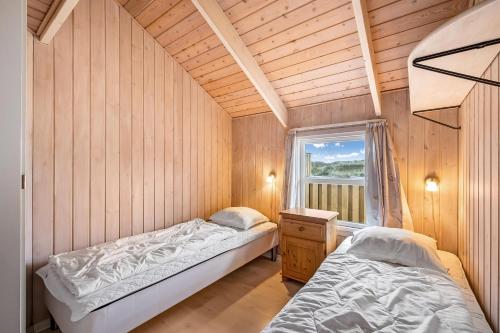 deux lits dans une chambre avec une fenêtre dans l'établissement Pool House With Spa And Sauna, 200 Meters From The North Sea, à Frøstrup