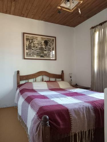 a bedroom with a bed with a purple and white blanket at Uco Slow in Tunuyán