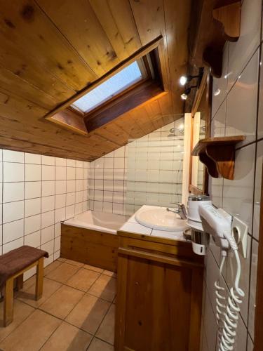 un bagno con lavandino e vasca da bagno di Appartement cosy pour 4 personnes en chalet de pierres a Saint-Martin-de-Belleville