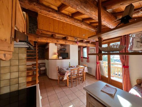 une cuisine et une salle à manger avec une table et des chaises dans l'établissement Appartement cosy pour 4 personnes en chalet de pierres, à Saint-Martin-de-Belleville