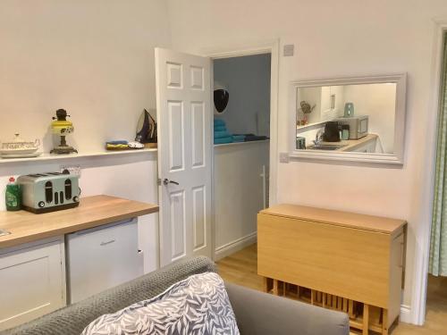 a living room with a kitchen with a table and a chair at Enchmarsh Farm Byre in Church Stretton
