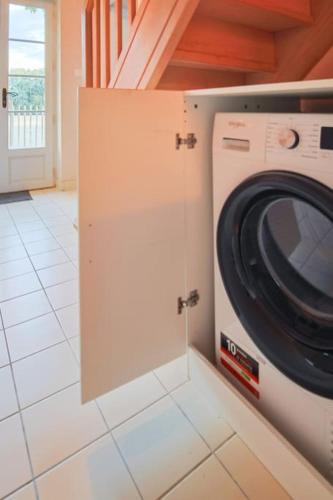 a washing machine in a kitchen with a door at La Maison des Champs in Cintegabelle