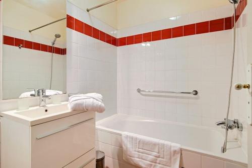 a white bathroom with a tub and a sink at La Maison des Champs in Cintegabelle