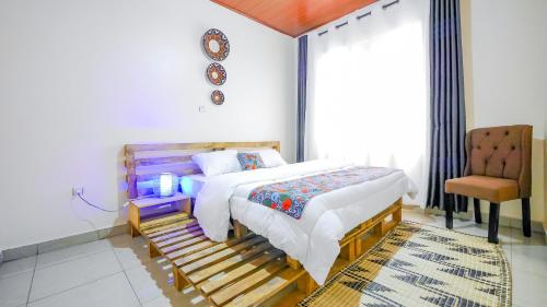 キガリにあるManna Stays, Kagaramaのベッドと椅子のある寝室