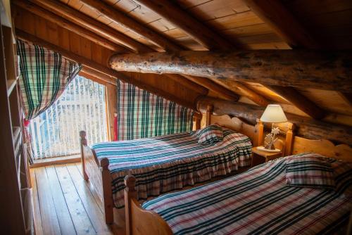 una camera con 2 letti in una baita di tronchi di Appartement cosy pour 4 personnes en chalet de pierres a Saint-Martin-de-Belleville