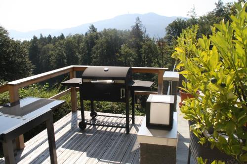 a grill on a deck with a view of a mountain at Pension Krakolinig in Pörtschach am Wörthersee