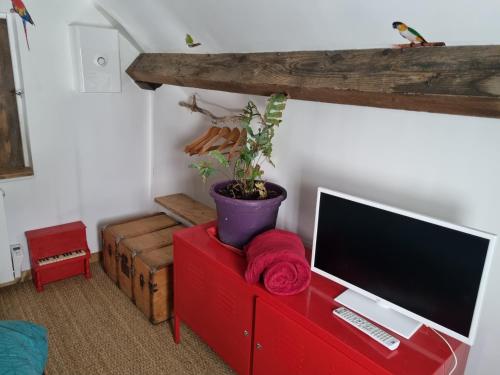 un salon avec une télévision sur un meuble rouge dans l'établissement Chez damdam et titi, à Dijon