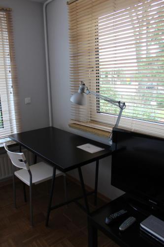 a desk with a lamp and a chair in a room at Gästehaus Lodge Fockbek in Fockbek