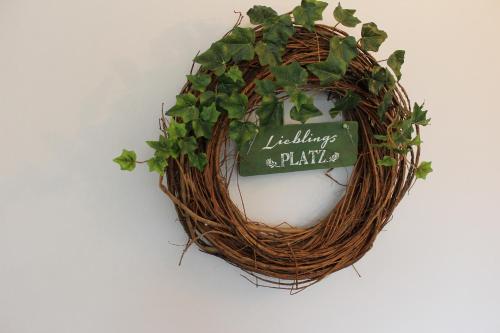 einen Kranz mit einem Schild, das Lilien und Pflanzen liest in der Unterkunft Gästehaus Lodge Fockbek in Fockbek