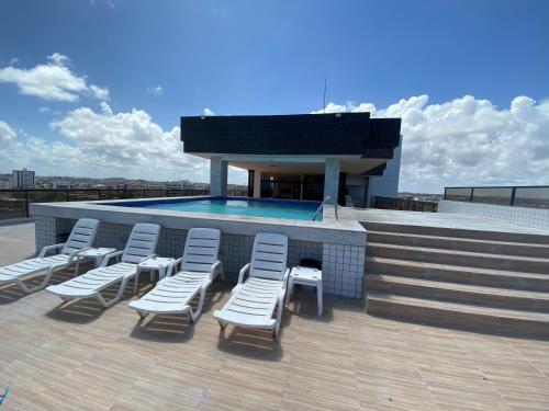 un gruppo di sedie e una piscina su un tetto di Flat beira mar, Olinda 4 Rodas 305 a Olinda