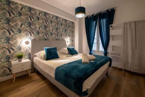 ein Schlafzimmer mit einem großen Bett mit einer blauen Decke in der Unterkunft Superbe appartement centre historique in Avignon