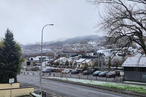 a snow covered city with cars parked on a street at Cocon Face au MontBlanc in Sallanches