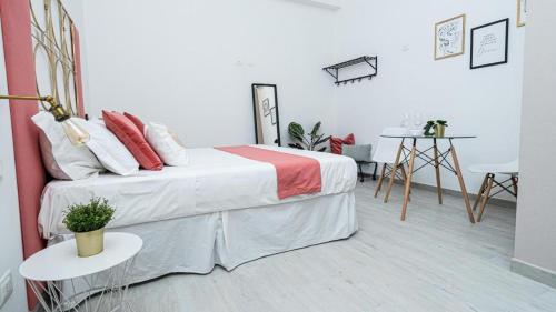a white bedroom with a bed and a table at Nice & Love in Noto