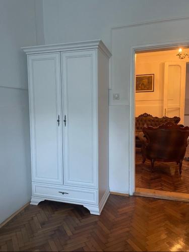 a white cabinet in a room with a wooden floor at Apartman Car new on booking in Odžaci