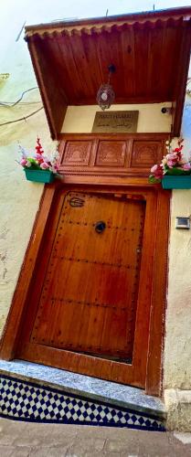 a wooden door with flowers on top of it at Riad Hamad Tijani in Fès