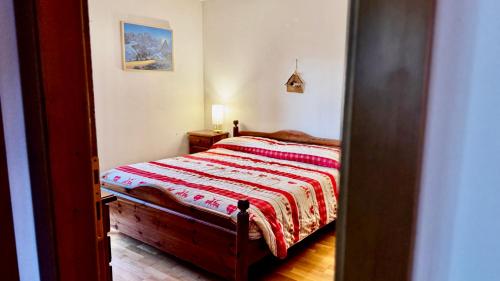 Un dormitorio con una cama con una manta roja encima. en Cavalese view, en Cavalese