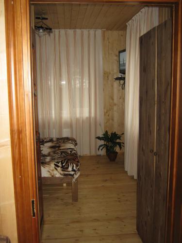 a hallway with a chair and a plant in a room at Санаторий "Синяк" гостиный двор "ПРОЛИСОК" in Sinyak