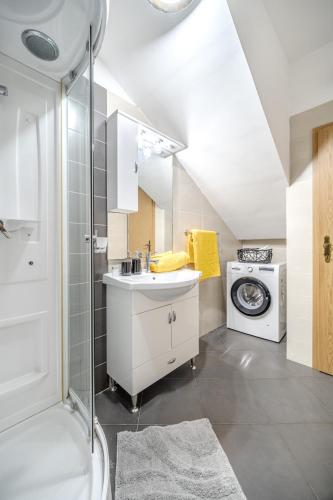 a bathroom with a sink and a washing machine at Moenia Apartments in Milna