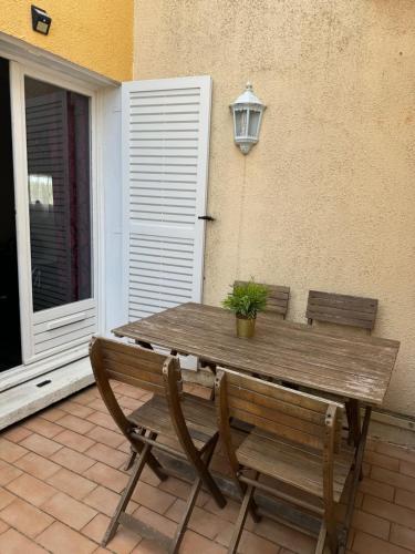 - une table en bois et 2 chaises sur la terrasse dans l'établissement Studio Baroque - Clim - Parking, au Cap d'Agde