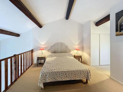 - une chambre avec un lit et 2 tables avec des lampes dans l'établissement Spacieux 2 pièces en duplex, à Villelongue-de-la-Salanque