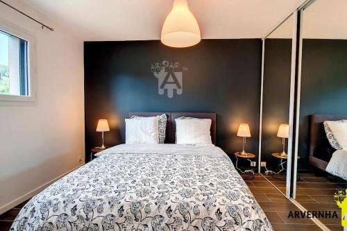 une chambre avec un grand lit et deux lampes dans l'établissement Meïzou Bardou, à Chambon-sur-Lac