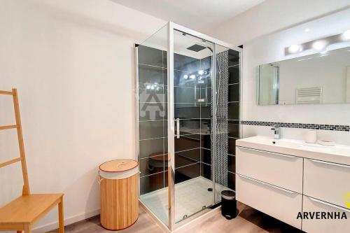 une salle de bain avec une douche en verre et un lavabo dans l'établissement Meïzou Bardou, à Chambon-sur-Lac