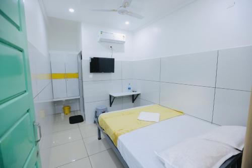 a hospital room with a bed and a tv at SR Residency in Kollam