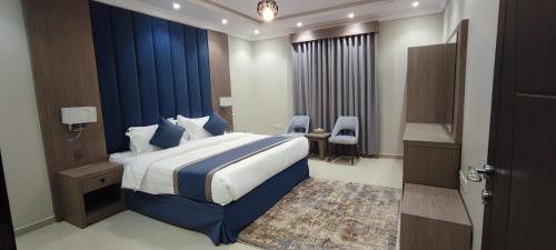 a bedroom with a large bed with a blue wall at اجنحة مأرز الايمان in Medina