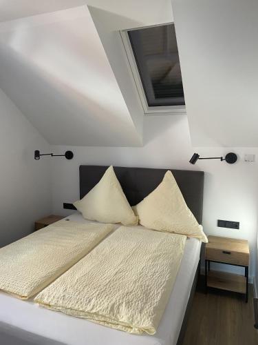 a bed with white sheets and pillows in a bedroom at Haus Breslau in Borkum