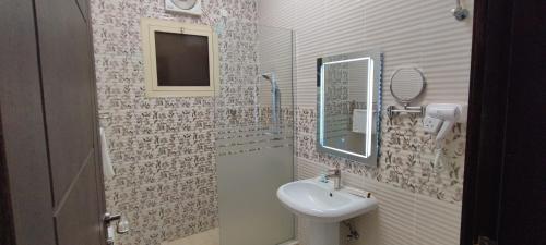 a bathroom with a sink and a mirror at اجنحة مأرز الايمان in Medina