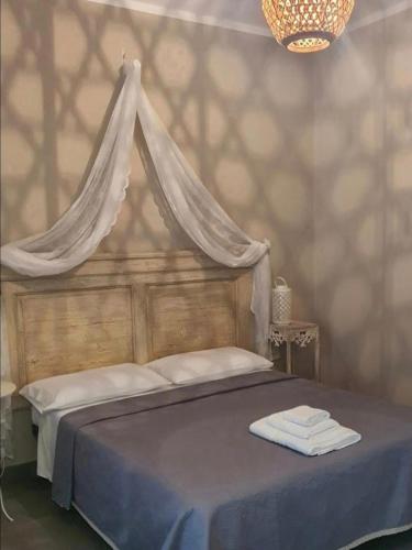 a bedroom with a canopy bed with towels on it at Dimora Storica Silver Room in Ruviano