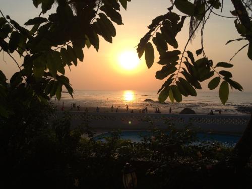 a sunset over the beach from a resort at Pension Les Palmiers in Kipé