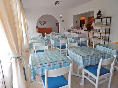 a dining room with tables and chairs and a room with at Dina Pension in Kokkari