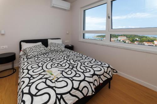 une chambre avec un lit noir et blanc et une fenêtre dans l'établissement Luxury Apartment NARONA Sea&City view, à Makarska