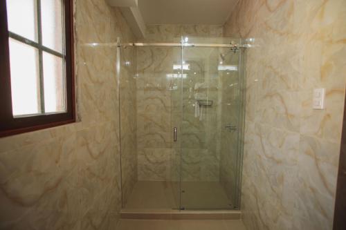 a shower with a glass door in a bathroom at Valle Del Sol in Urubamba