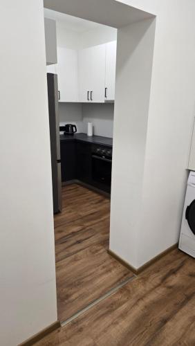 a kitchen with white cabinets and a wooden floor at Apartment Lovro in Ivanec