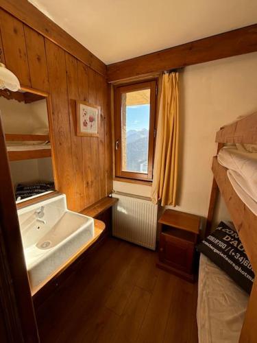 La salle de bains est pourvue d'un lavabo, d'un lit et d'une fenêtre. dans l'établissement Chalet de l'Ours - Pla d'Adet, à Cadeilhan-Trachère