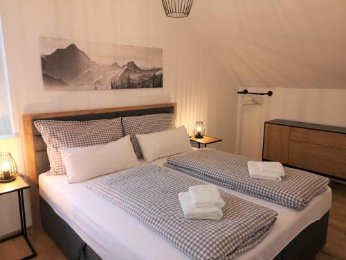 Tauplitz Panorama Apartment, 75qm, Balkon und Sauna في توبليتز: غرفة نوم بها سرير عليه منشفتان