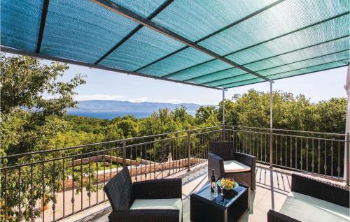 a patio with chairs and a table on a balcony at Awesome Home In Krk With Wifi in Risika